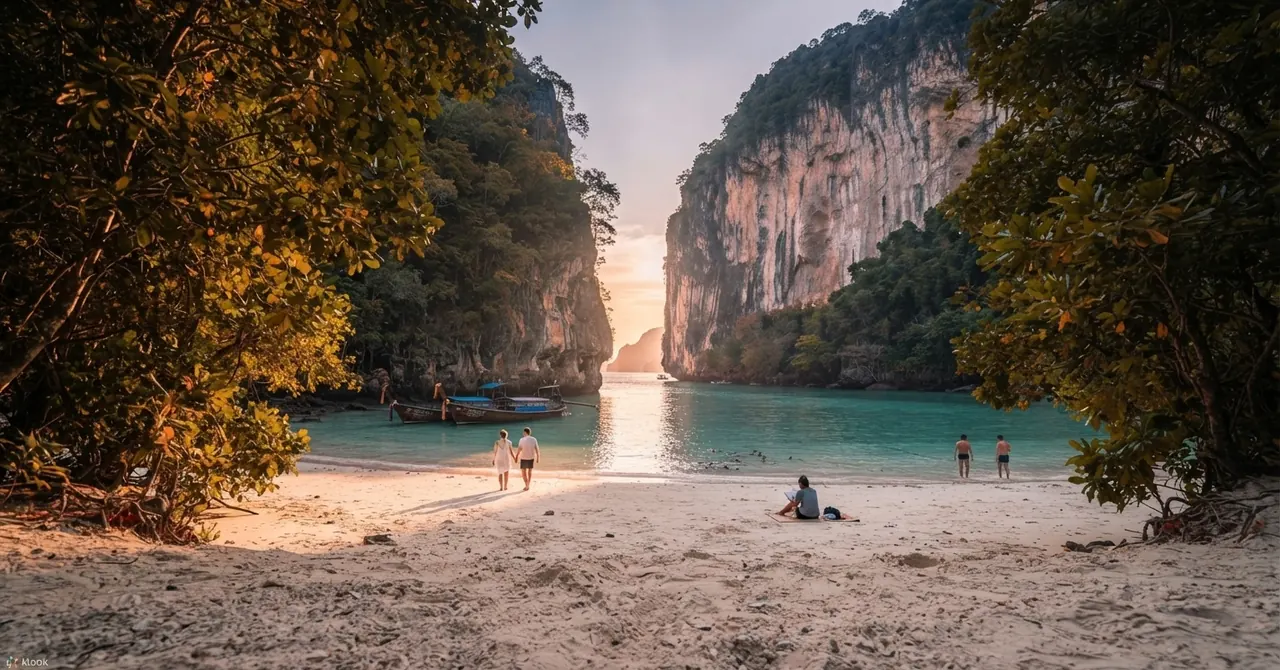 Sandy beach between two limestone cliffs with a few people on the shore