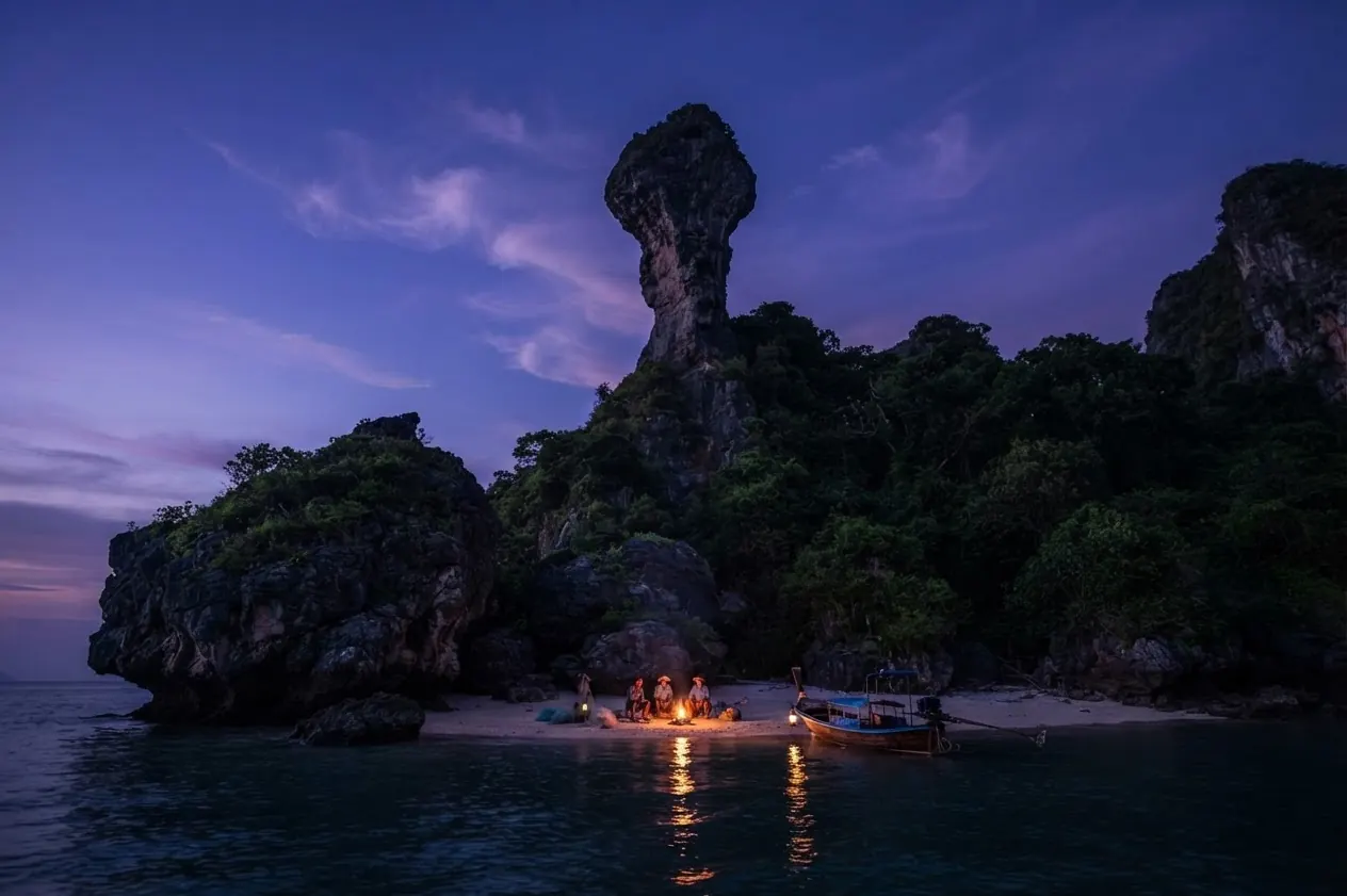 Chicken Island's chicken-head rock above a beach campfire at dusk
