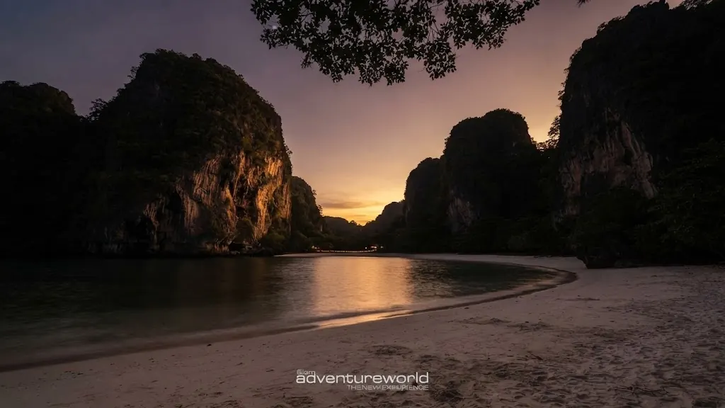 Quiet beach between limestone cliffs at dusk in Krabi